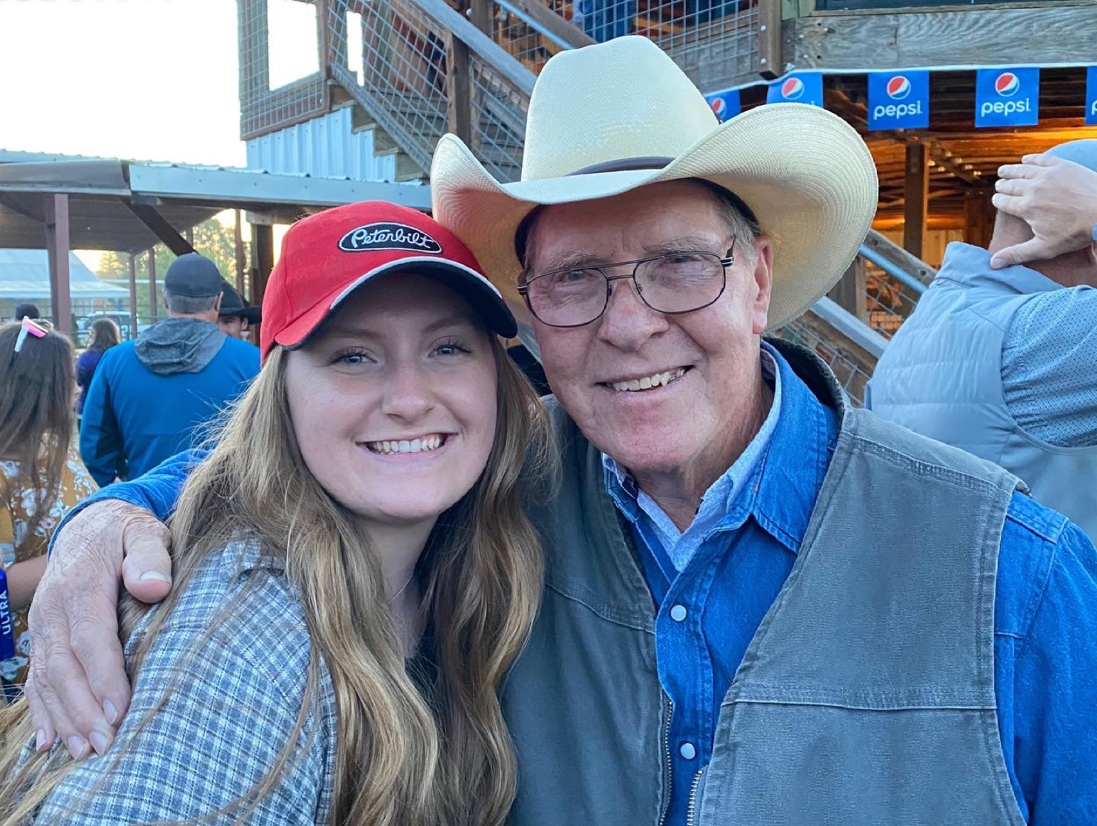 Two people smiling together at an outdoor event.